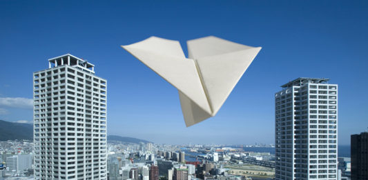 高層マンションを飛ぶ紙飛行機